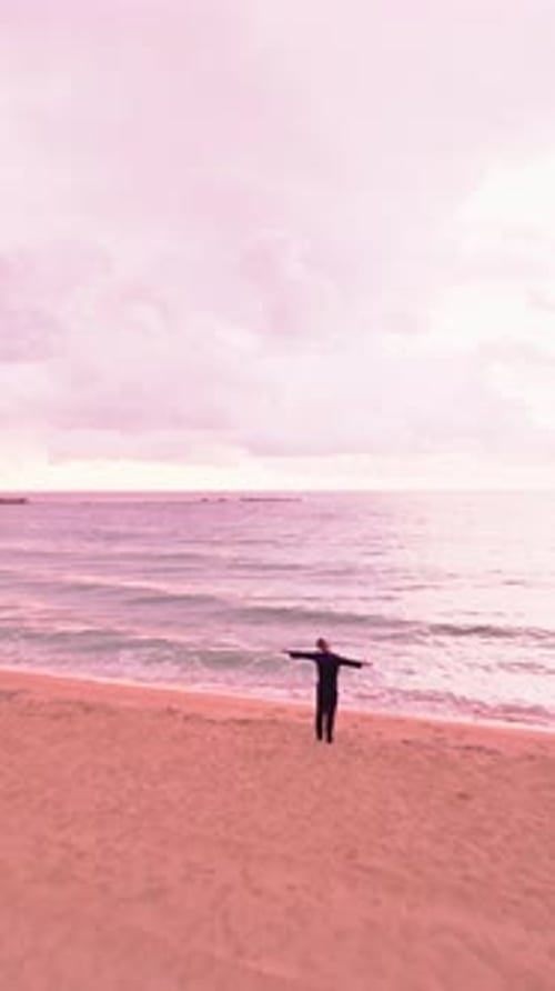 Solitary Man Enjoying Freedom on the Beach at Sunset