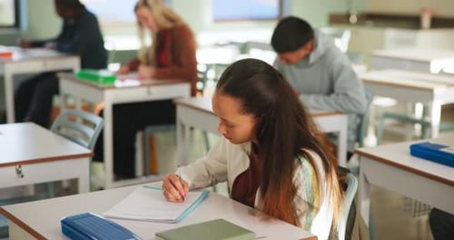Students Writing at Desks in Classroom Setting