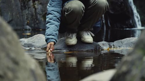 EightYearOld Girl Hand Touches The Calm Waters Of A Quiet Forest Lake
