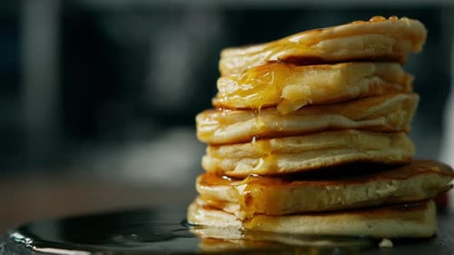 Close up honey spreads over the pancakes