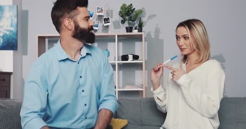 Excited Couple Reacting to Positive Pregnancy Test at Home
