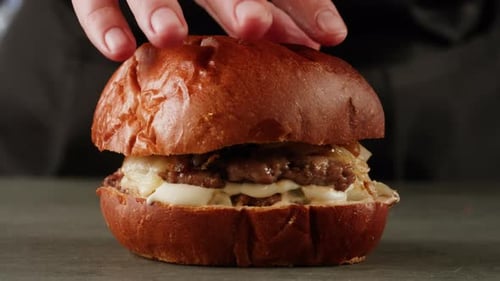 American Fat Smash Burger with Bacon Slices and Cheese on Grill Closeup Macro Beef or Pork Cutlet
