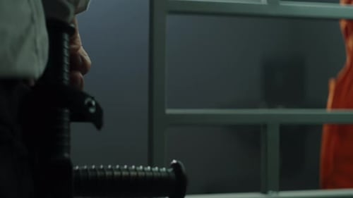 Close Up of Prison Guard Giving Phone to Criminal