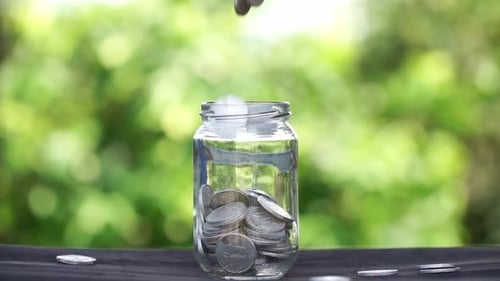 Coins Falling into Glass Jar, Savings Concept
