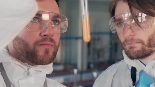 Scientists Examine Test Tube with Liquid in Lab