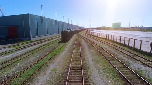 Aerial Drone Shot of Moving Freight Train in Cargo Railway Station