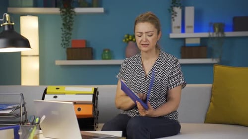 Home office worker woman looking at the file angrily.