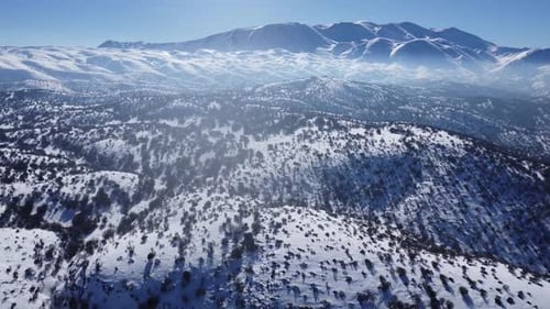 On a sunny day in snowy high mountains, an amazing sight unfolds. The white blanket of snow gleams u