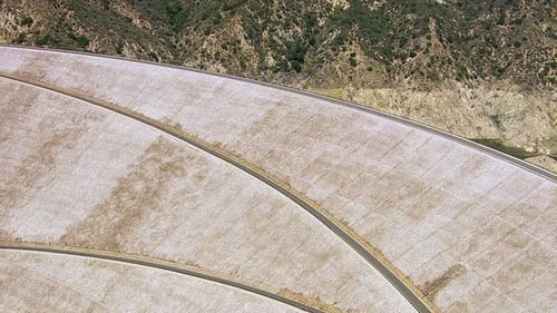 Luftaufnahme eines Staudamms in Südkalifornien, eingebettet in eine hügelige Bergkette