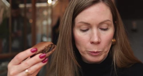 Close Up of Young Woman Bite Chocolate Dessert Cake and Take Sip Coffee From Cup