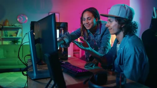 Friends Discussing Computer in Colorful Room at Night