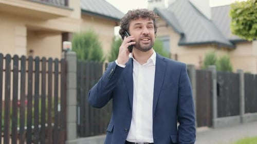 Portrait of Serious Caucasian Male Professional Standing in City and Talking on Smartphone Handsome