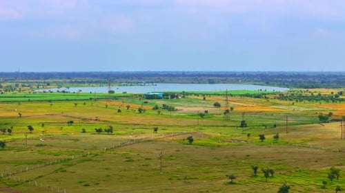 Vast Green Fields with Lake and Clear Sky