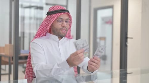 Young Adult Counting Cash Money in Office