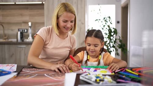 Mother teaching daughter art and crafts at home