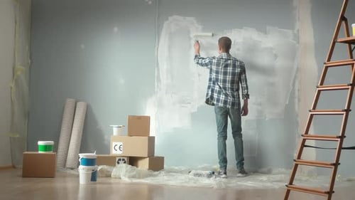 Adult Painting Interior Wall With a Roller