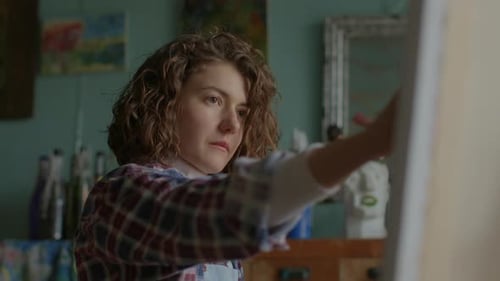 Young Woman Painting on Canvas in Art Studio