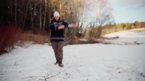 Young Adult Gathering Twigs in Winter Scene