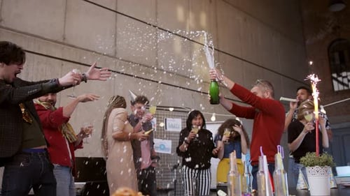 Grupo de colegas fazendo uma grande festa no escritório, abrindo champanhe.