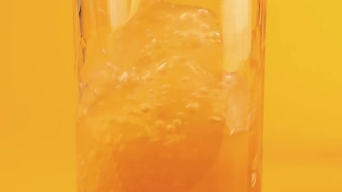 Orange Beverage Pouring into a Clear Glass