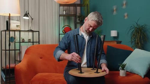 Man Assembling Wooden Table at Home on Couch