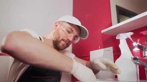 Man Cleaning Bathroom Sink Giving Thumbs Up