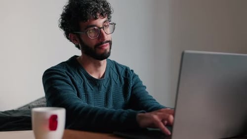 Young Adult Types on Laptop Computer Indoors