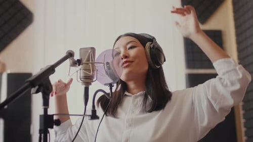 Sänger tritt leidenschaftlich auf, während er in einem professionellen Studio-Setup aufnimmt