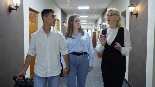 Receptionist Leading Young Couple to Booked Hotel Room