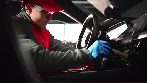 Man Carefully Cleans Car Interior With Brush