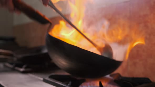 Process of cooking over high heat in the flame of boiling oil on a gas ...