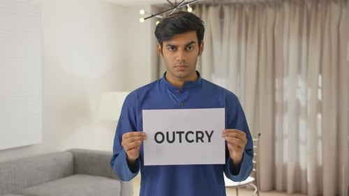 Garçon indien en colère tenant une bannière OUTCRY