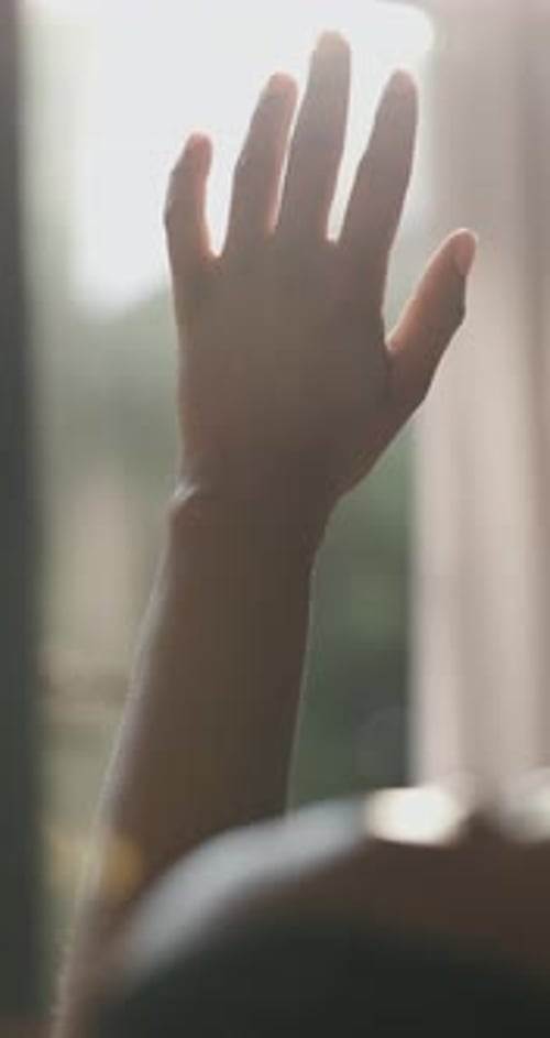Hand, sunlight and person at resort with window, gratitude and reflection on holiday trip