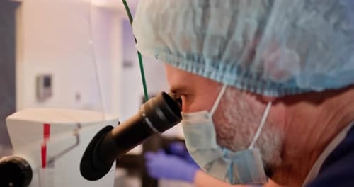 Macro Close Up Footage of a Male Scientist Wearing Medical Mask and Looking Into