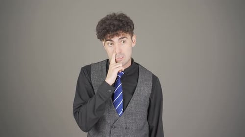 Young Adult Man Pondering and Touching His Face