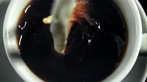 A Stream of Milk is Poured Into the Black Coffee Filmed on a Highspeed Camera at 1000 Fps
