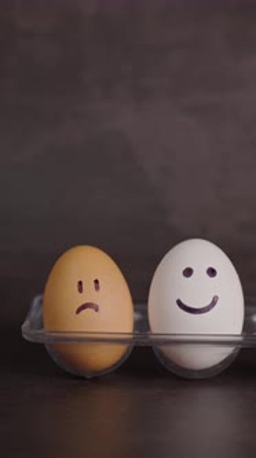 Sad and Happy Eggs on Dark Grey Background