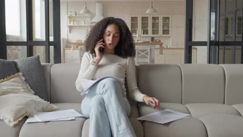 Woman Sitting on Sofa Talking on the Phone