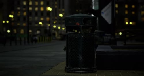 Trash Bin Illuminated By Street Lights in Urban City After Dark