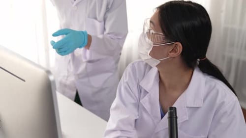 Scientists working in laboratory setting with microscope