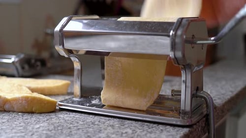 Flattening Dough On Pasta Roller - Homemade Pasta. - wide shot