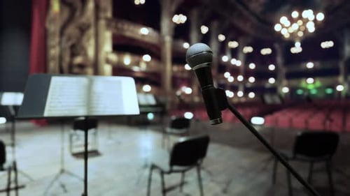 A Microphone and a Sheet Music Stand in Front of a Stage