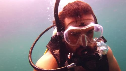 4k video footage of a young man scuba diving in the ocean