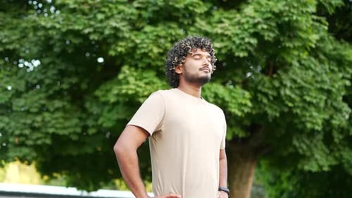 Man Relaxing and Breathing Deeply in Urban Park