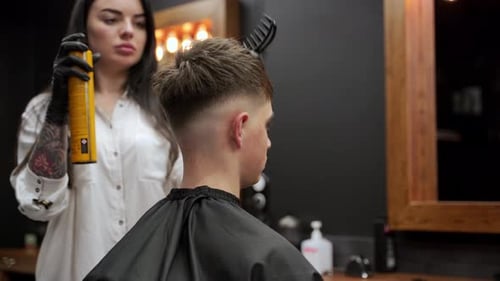 Stylist Combing and Styling Young Adult Hair in Salon