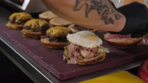 Chef Assembling Gourmet Burger in Restaurant Kitchen