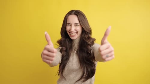 Excited Young Woman Gives Two Thumbs Up