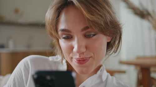 Smiling Woman Using Mobile Phone Indoors