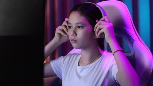 Close Up Of Asian Teen Girl Gamer Wearing Head Phones And Start Play Video Game On Computer
