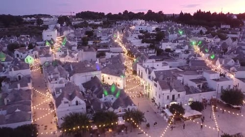 Aerial Drone View of Alberobello, Puglia, Italy - Trulli, Old Town and Lights by Sunset